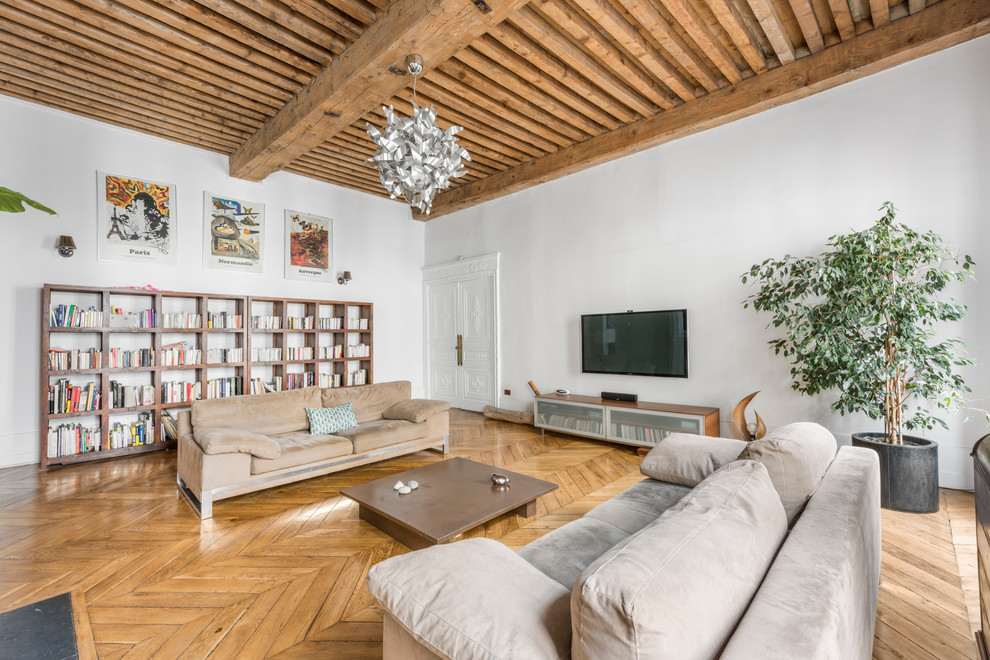 Идея дизайна: открытая гостиная комната среднего размера в современном стиле с светлым паркетным полом, телевизором на стене, белыми стенами и коричневым диваном без камина