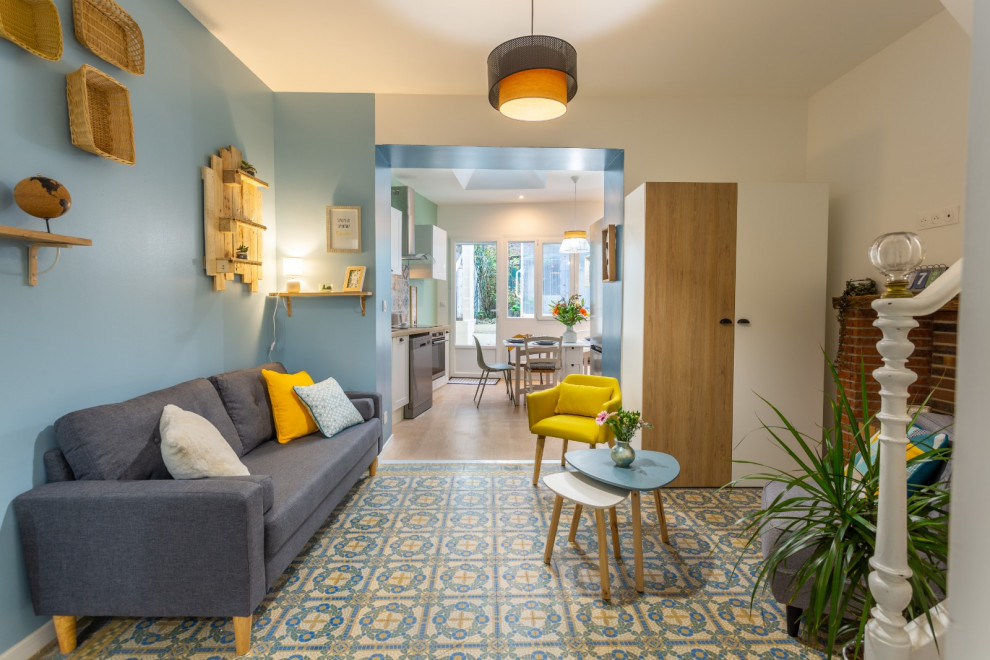 Imagen de salón abierto de estilo de casa de campo pequeño con paredes azules, suelo de baldosas de cerámica y televisor colgado en la pared