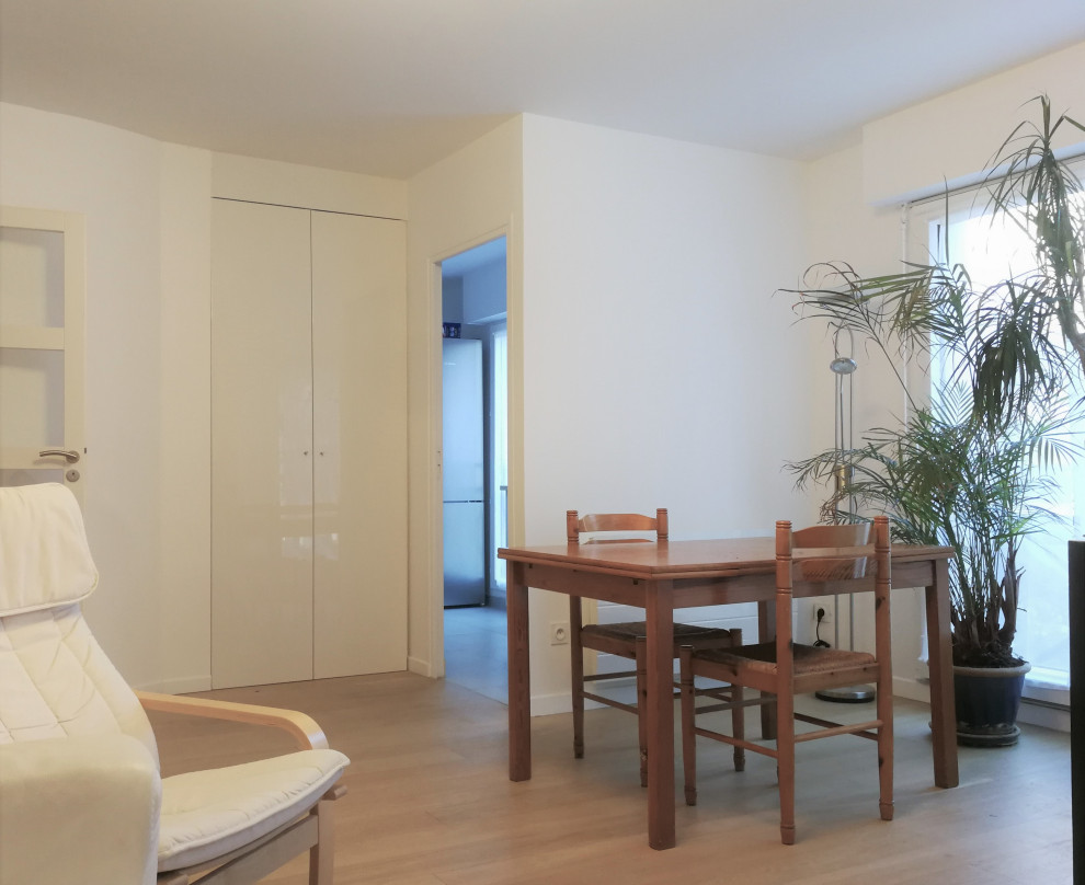 На фото: маленькая изолированная гостиная комната в современном стиле с белыми стенами, паркетным полом среднего тона, отдельно стоящим телевизором и коричневым полом для на участке и в саду с