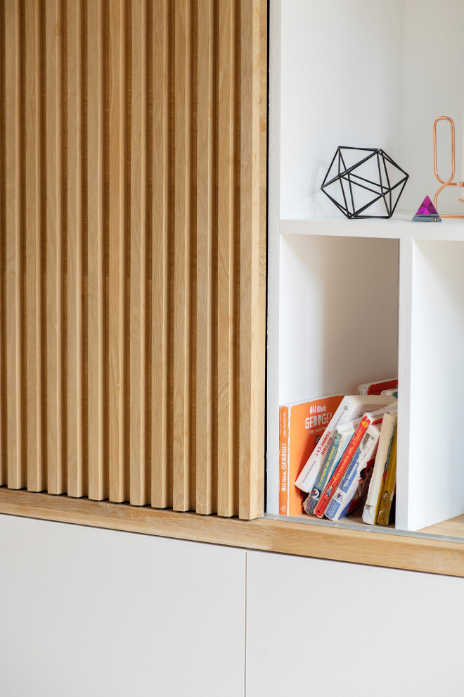 Exemple d'un salon scandinave de taille moyenne et ouvert avec une bibliothèque ou un coin lecture, un mur blanc, parquet clair, aucune cheminée, un téléviseur fixé au mur et un sol beige.