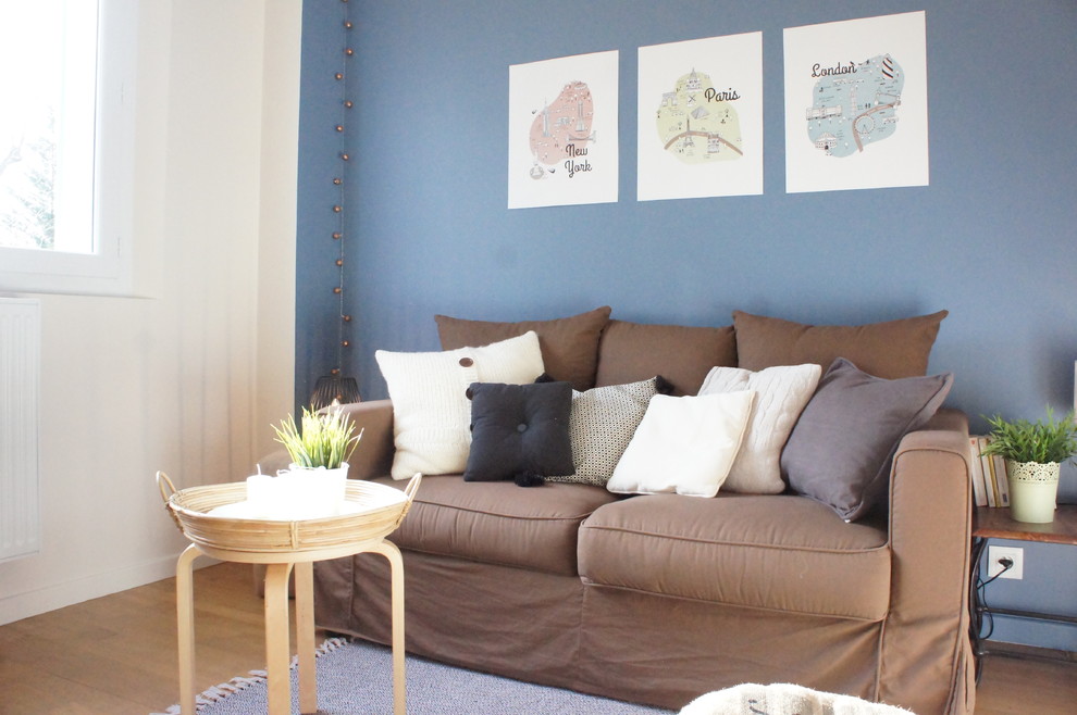 Idées déco pour un salon moderne avec un mur bleu et parquet clair.