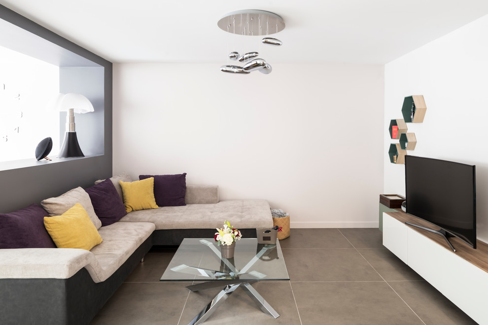 Cette image montre un grand salon design ouvert avec un mur gris, un sol en carrelage de céramique, aucune cheminée, un téléviseur indépendant et éclairage.
