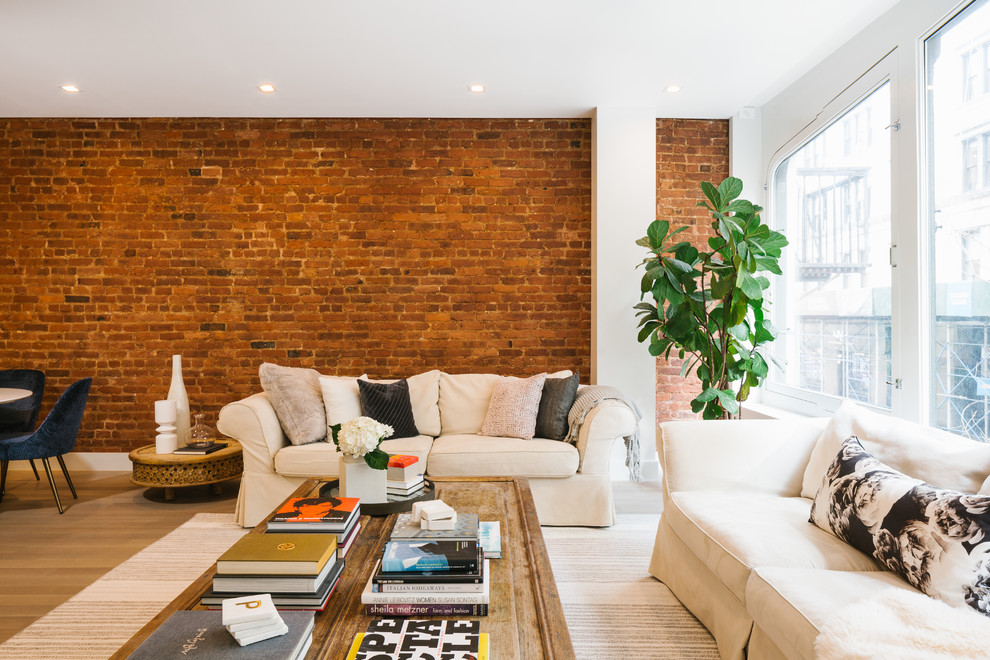 Esempio di un soggiorno design aperto con pareti bianche, pavimento in legno massello medio e pavimento marrone