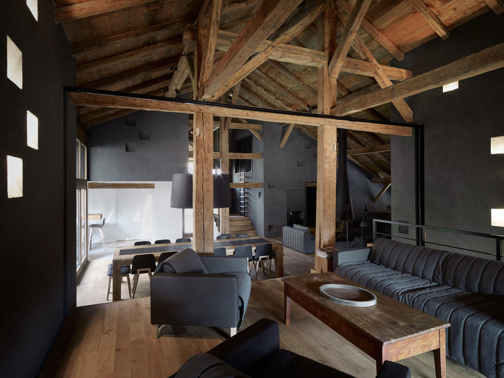 Cette photo montre un salon tendance avec un mur noir, un sol en bois brun, cheminée suspendue, un manteau de cheminée en métal et un téléviseur dissimulé.