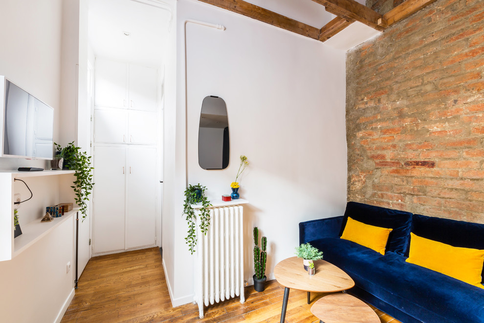 Kleines Industrial Wohnzimmer ohne Kamin, im Loft-Stil mit Hausbar, weißer Wandfarbe, braunem Holzboden, TV-Wand und braunem Boden in Paris