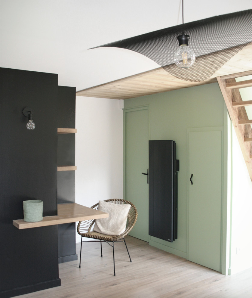 Cette image montre un salon design avec un mur vert et parquet clair.