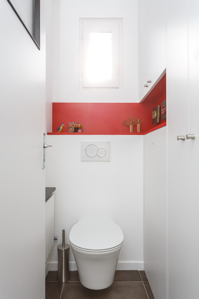 Foto på ett funkis toalett, med en vägghängd toalettstol och vita väggar