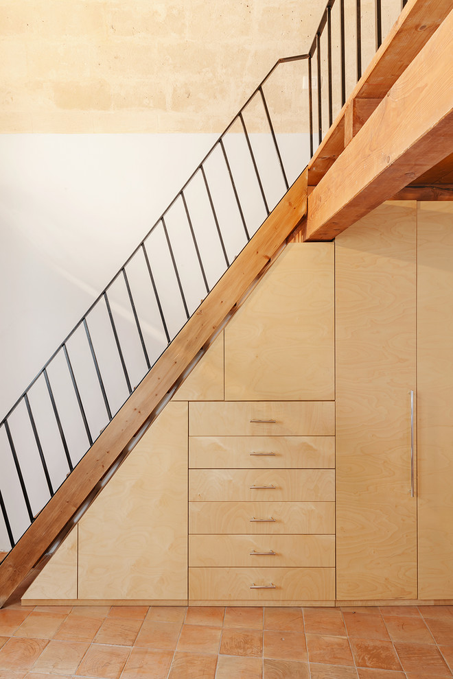 На фото: лестница в средиземноморском стиле с кладовкой или шкафом под ней
