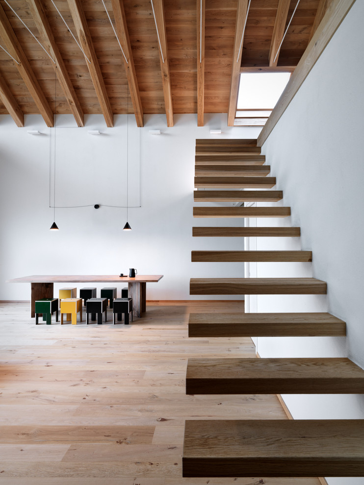 Medium sized modern wood floating staircase in Milan with open risers.