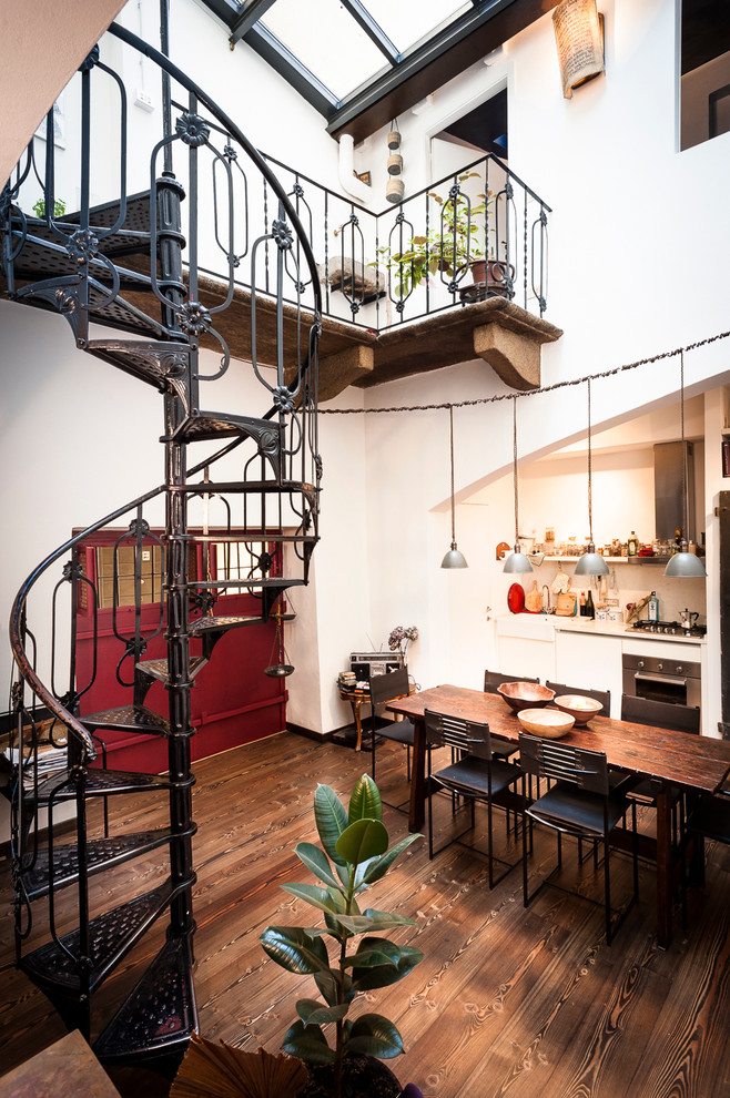 Idée de décoration pour un grand escalier sans contremarche hélicoïdal bohème avec des marches en métal et un garde-corps en métal.