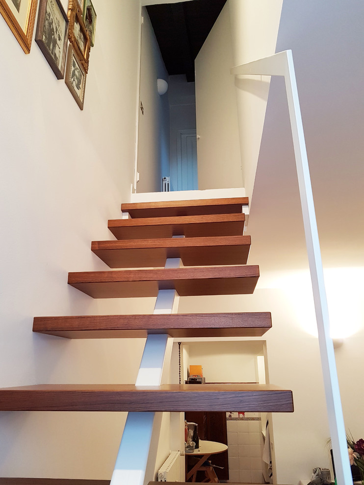Modelo de escalera en L minimalista pequeña con escalones de madera, contrahuellas de madera y barandilla de metal