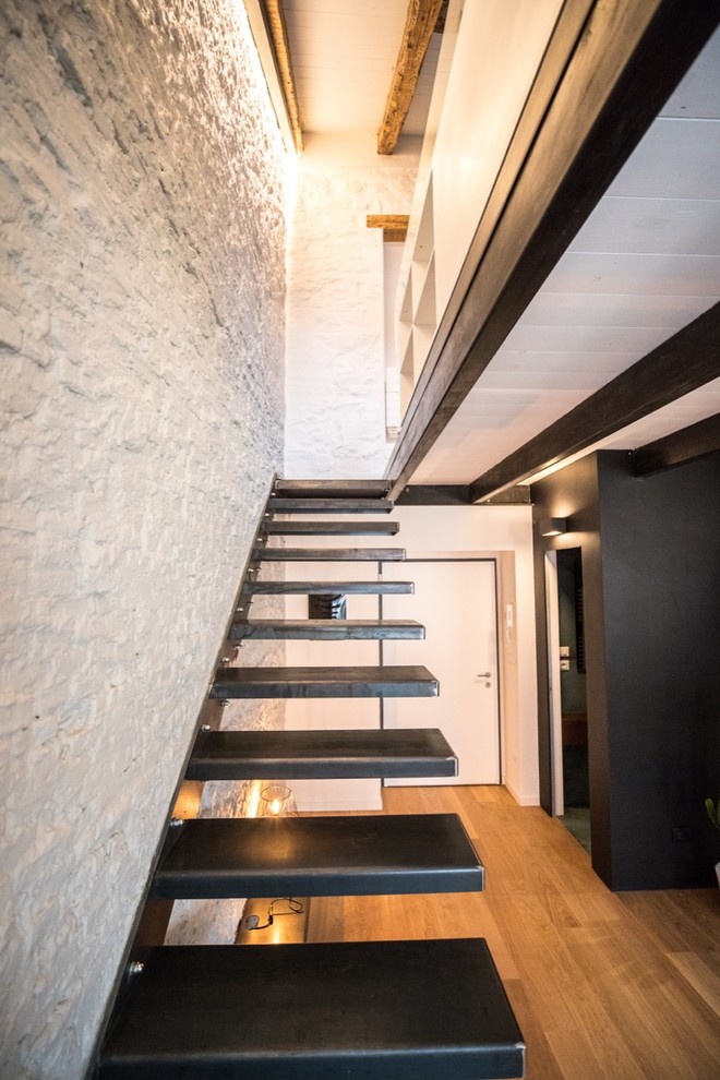 他の地域にあるお手頃価格の小さなインダストリアルスタイルのおしゃれなスケルトン階段 (金属の蹴込み板) の写真