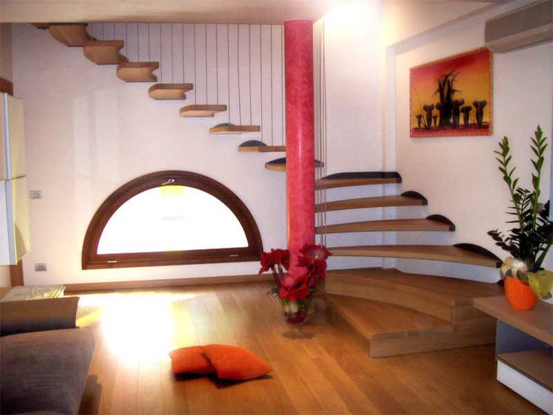 На фото: большая угловая лестница в современном стиле с деревянными ступенями и перилами из тросов без подступенок