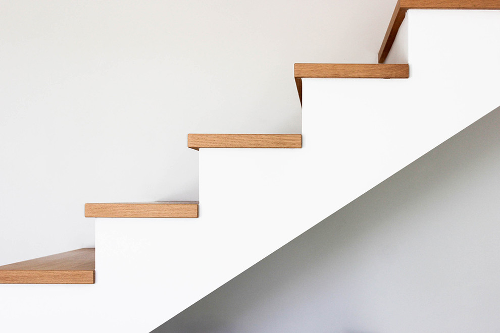 Exemple d'un escalier droit tendance de taille moyenne avec des marches en bois et des contremarches en béton.