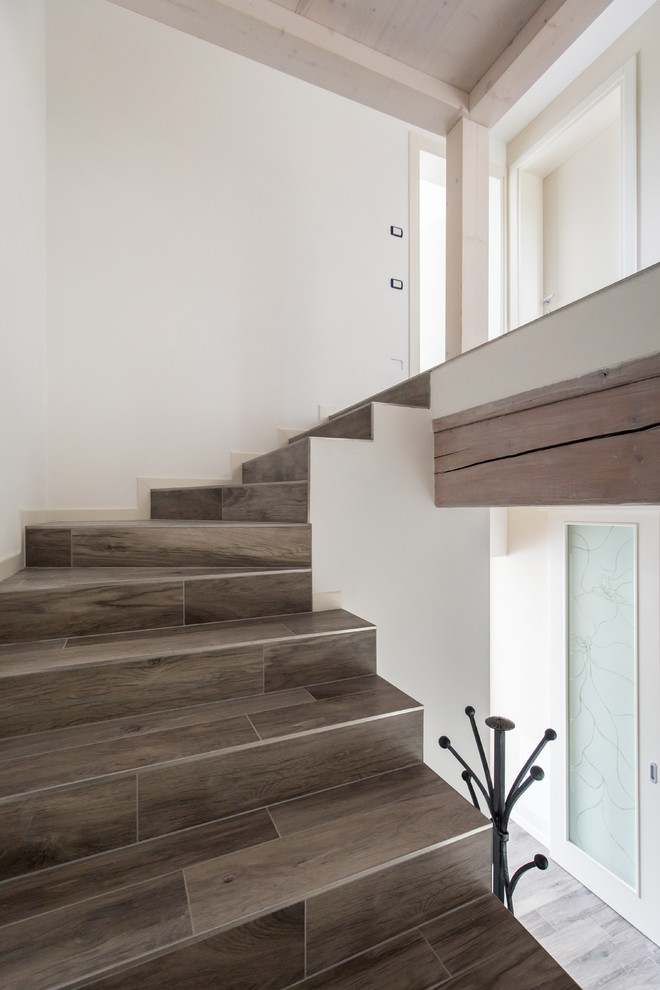 Идея дизайна: п-образная лестница в современном стиле с ступенями из плитки и подступенками из плитки