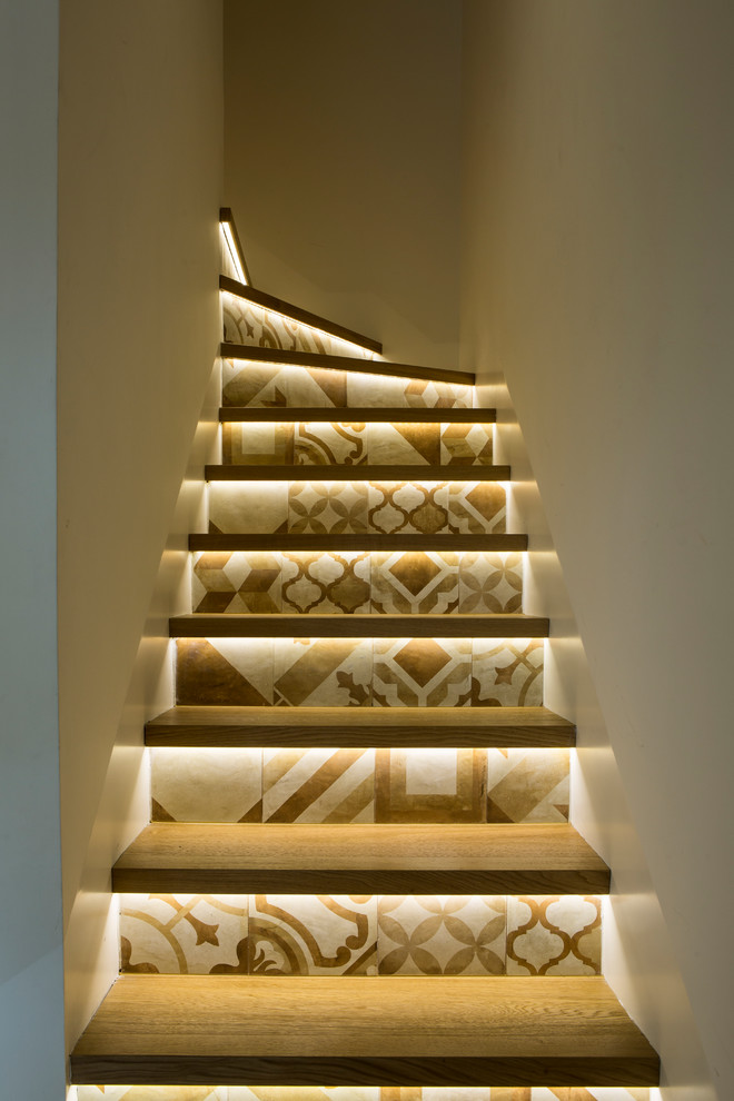 Modern inredning av en trappa i målat trä, med sättsteg i kakel