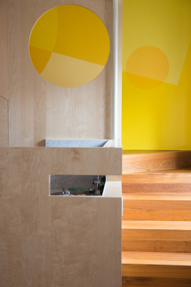 Diseño de escalera en L contemporánea de tamaño medio con escalones de madera, contrahuellas de madera, barandilla de madera y boiserie