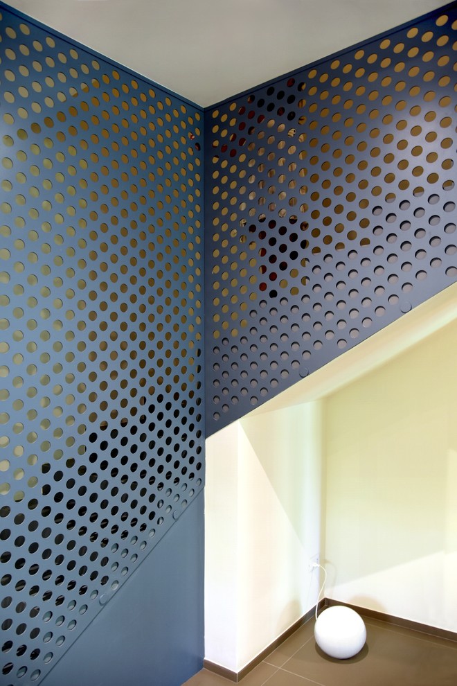 Foto di una scala a "L" design di medie dimensioni con pedata piastrellata, alzata piastrellata e parapetto in metallo