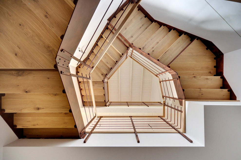 Imagen de escalera recta romántica de tamaño medio con escalones de madera, contrahuellas de madera y barandilla de metal