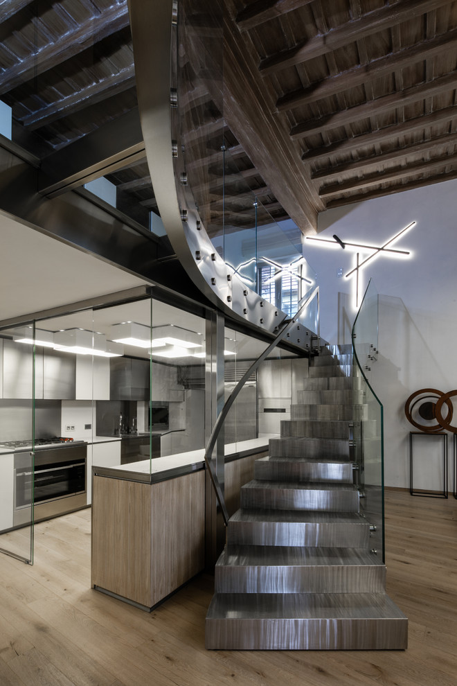 Photo of a large urban metal straight glass railing staircase in Rome with metal risers and feature lighting.