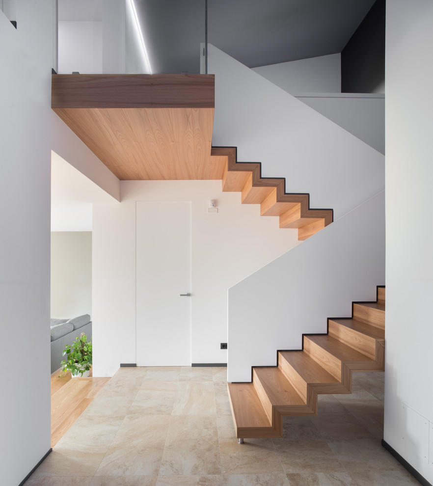 Aménagement d'un escalier contemporain en U avec des marches en bois, des contremarches en bois et palier.