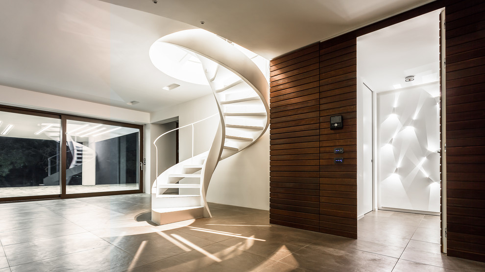 На фото: винтовая лестница среднего размера в современном стиле с металлическими ступенями без подступенок с