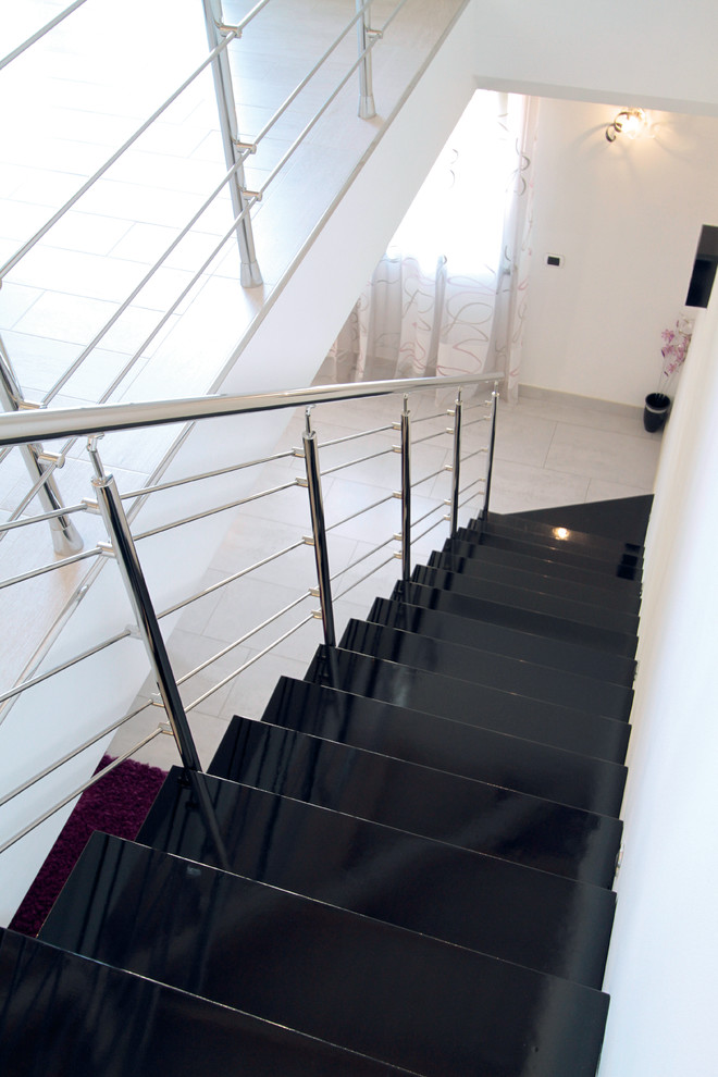 Imagen de escalera suspendida contemporánea grande sin contrahuella con escalones de madera pintada