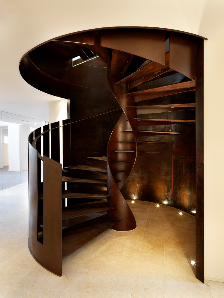 На фото: большая винтовая лестница в стиле лофт с металлическими ступенями и металлическими перилами