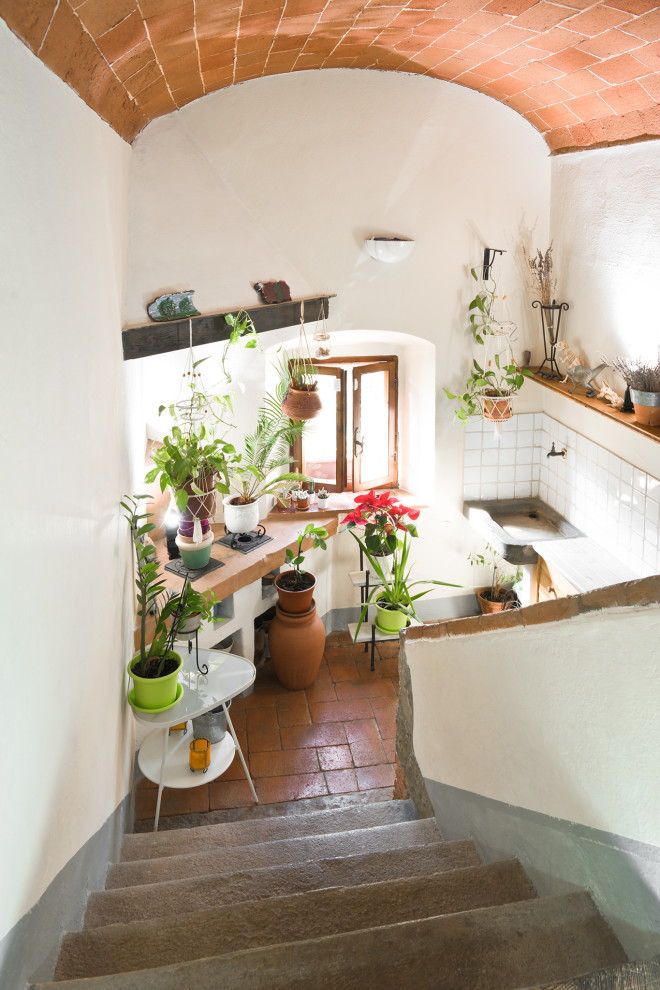 Aménagement d'un petit escalier romantique en U avec des marches en pierre calcaire, des contremarches en pierre calcaire et un garde-corps en matériaux mixtes.