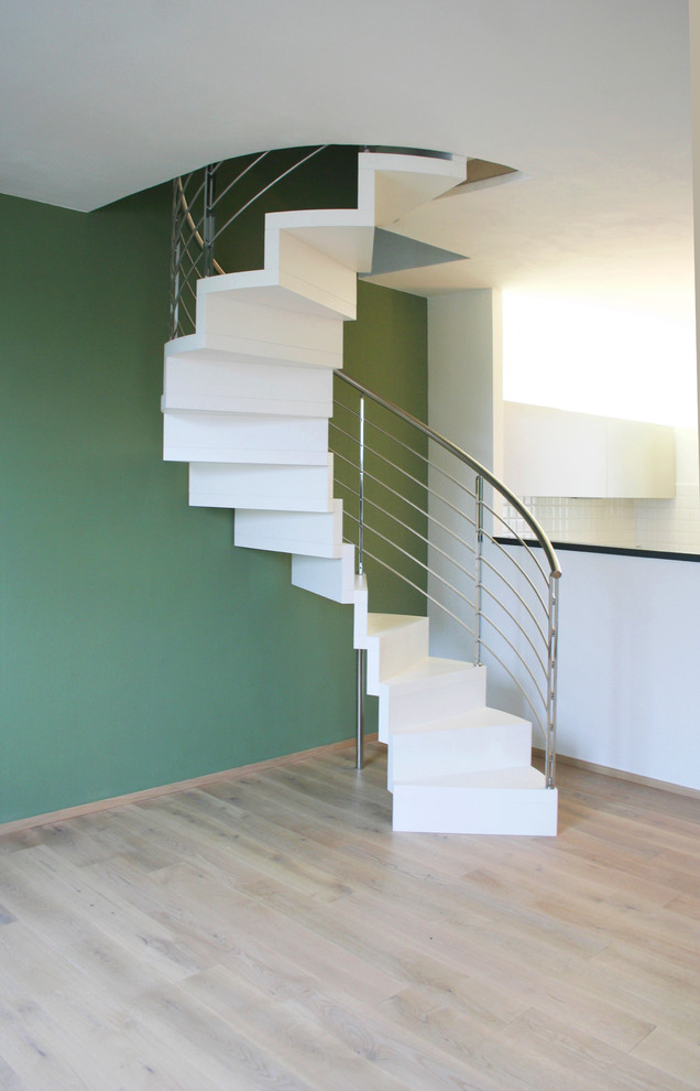 Cette image montre un escalier peint hélicoïdal design de taille moyenne avec des marches en bois peint et un garde-corps en métal.