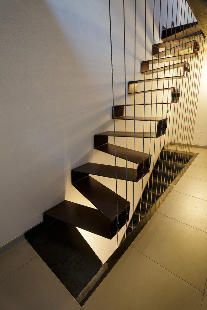 Imagen de escalera recta minimalista pequeña con escalones de metal y barandilla de cable