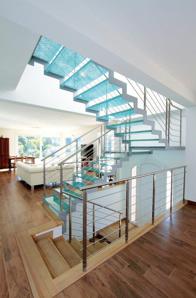 Свежая идея для дизайна: огромная п-образная лестница в современном стиле с стеклянными ступенями без подступенок - отличное фото интерьера