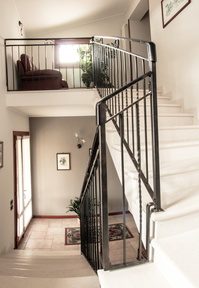 Exempel på en mellanstor klassisk u-trappa i marmor, med sättsteg i marmor och räcke i metall