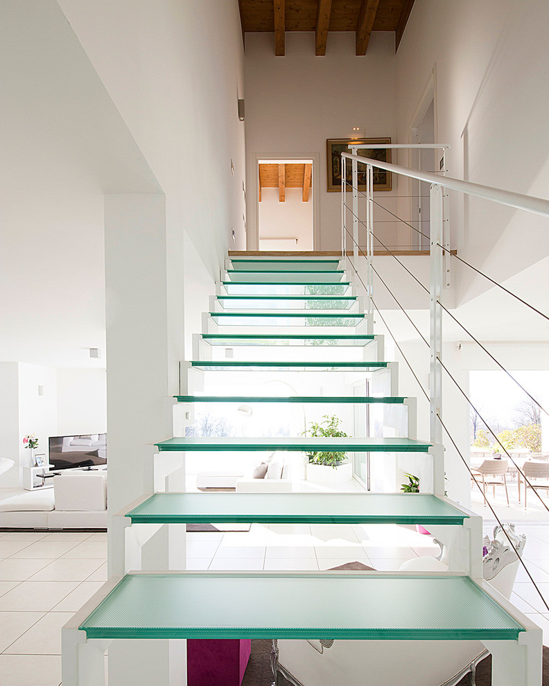 Idée de décoration pour un escalier droit design de taille moyenne avec des marches en verre et éclairage.