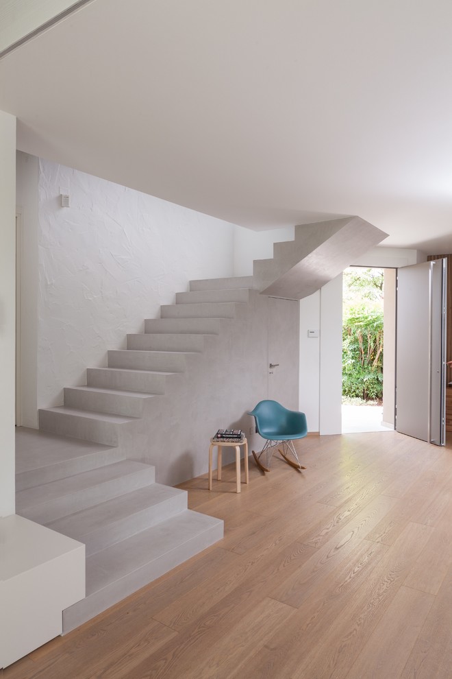 Inspiration for a modern concrete u-shaped staircase in Venice with concrete risers.