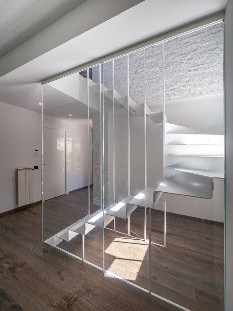Стильный дизайн: п-образная металлическая лестница среднего размера в современном стиле с металлическими ступенями и стеклянными перилами - последний тренд