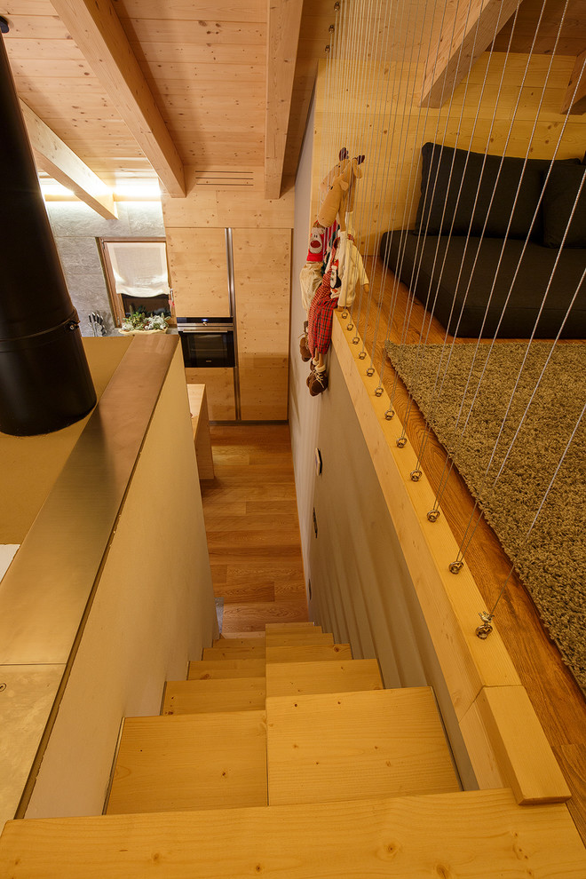 Стильный дизайн: маленькая прямая лестница в стиле рустика с деревянными ступенями и перилами из тросов без подступенок для на участке и в саду - последний тренд