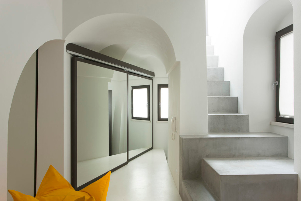 Small mediterranean concrete straight staircase in Bari with concrete risers.