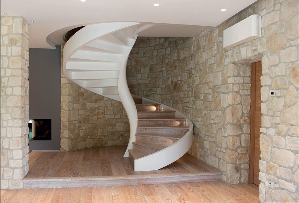 На фото: винтовая деревянная лестница среднего размера в современном стиле с деревянными ступенями с