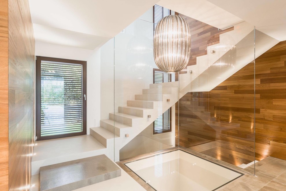Große Moderne Treppe in L-Form mit Marmor-Setzstufen in Mailand