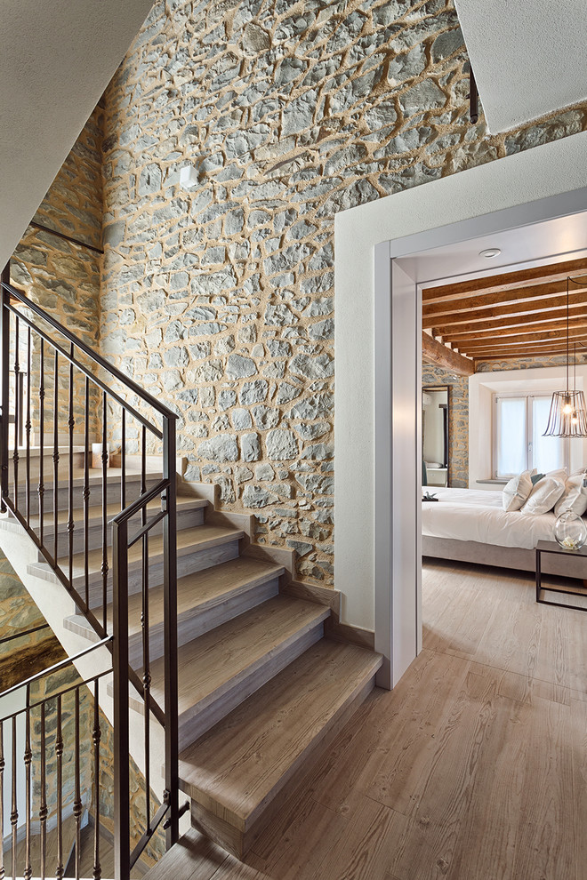 Mittelgroße Moderne Holztreppe in L-Form mit Holz-Setzstufen und Stahlgeländer in Bologna