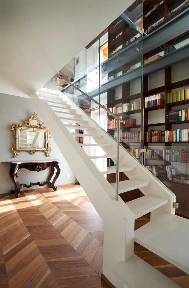 Пример оригинального дизайна: огромная угловая лестница в стиле неоклассика (современная классика) с мраморными ступенями и металлическими перилами без подступенок