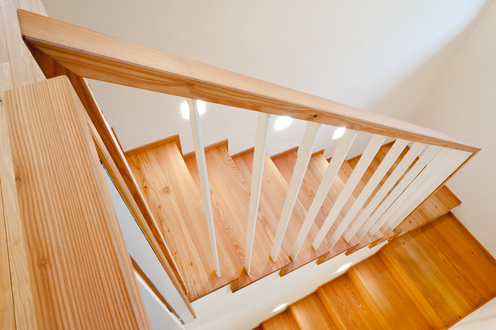 Imagen de escalera en U nórdica con escalones de madera y barandilla de madera