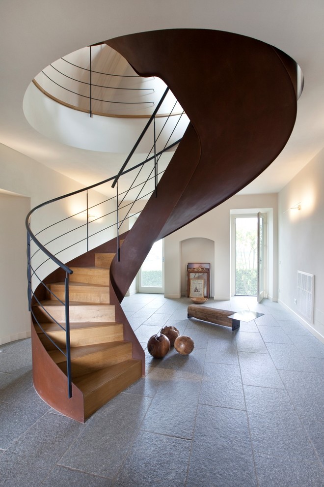 Imagen de escalera curva contemporánea con escalones de madera y contrahuellas de madera