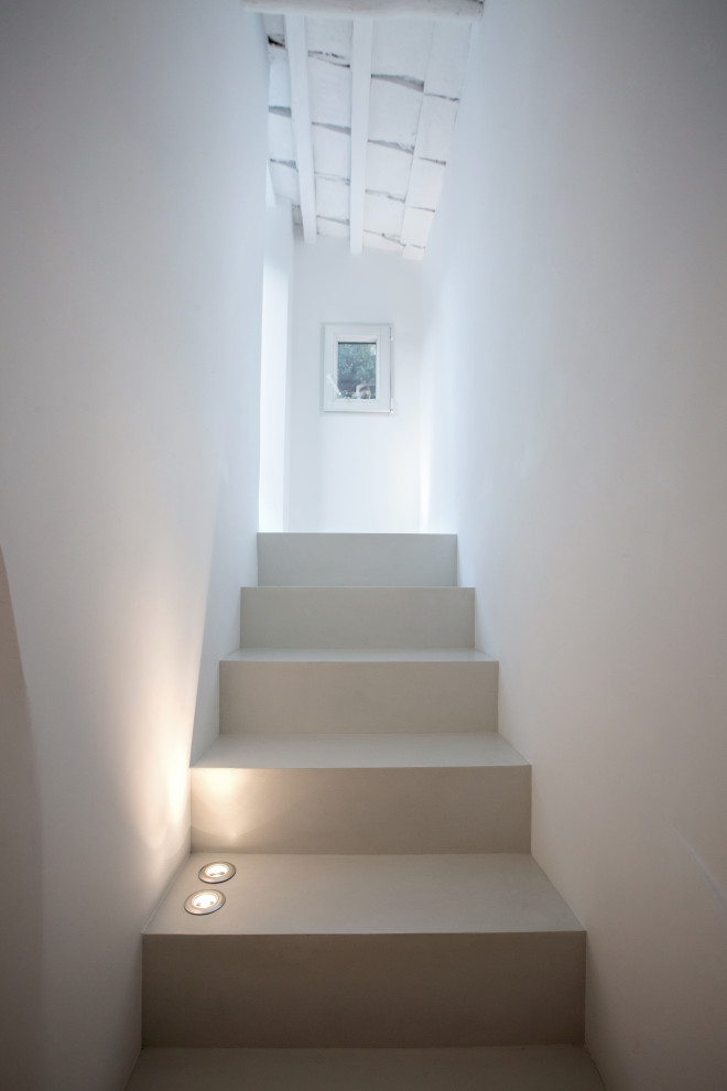 Photo of a small mediterranean concrete straight staircase in Other with concrete risers.