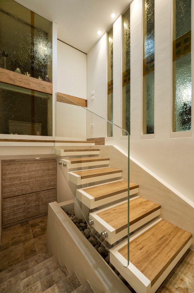 Ejemplo de escalera recta actual pequeña sin contrahuella con escalones de madera y barandilla de vidrio