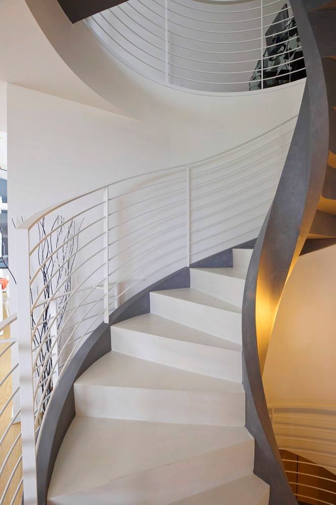 Diseño de escalera de caracol moderna grande con escalones de hormigón, contrahuellas de hormigón y barandilla de metal