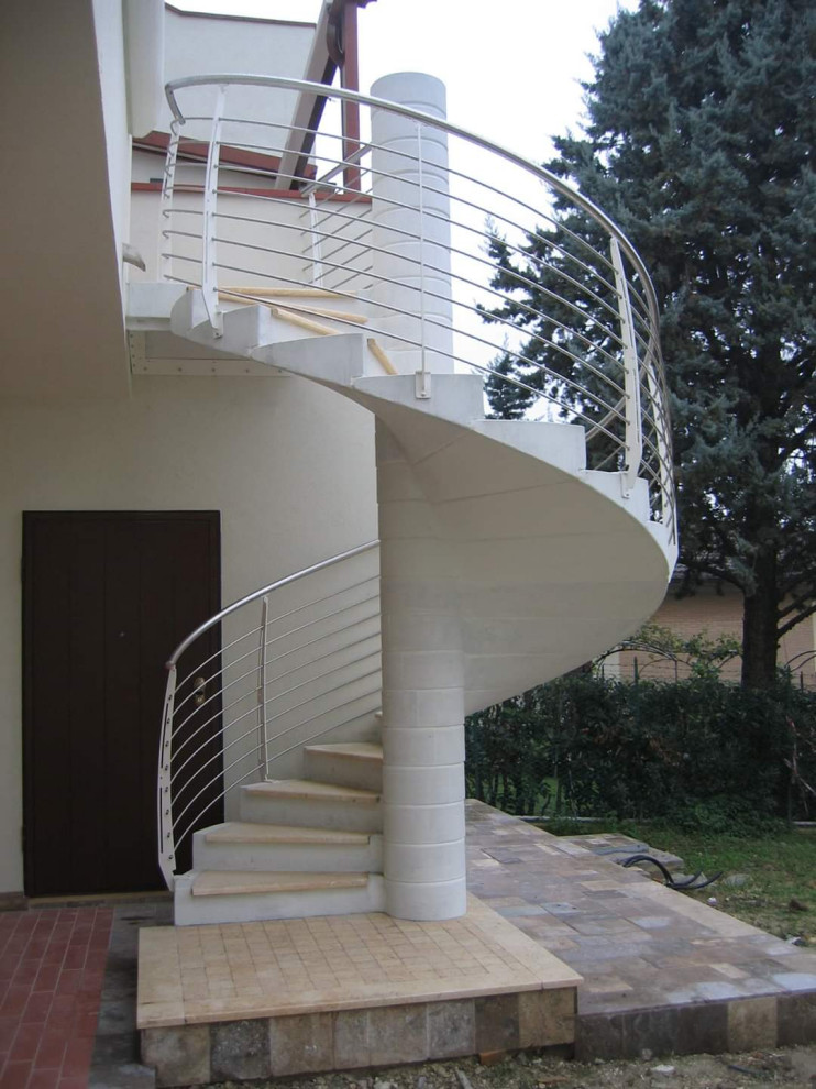 На фото: винтовая бетонная лестница в современном стиле с мраморными ступенями и металлическими перилами с