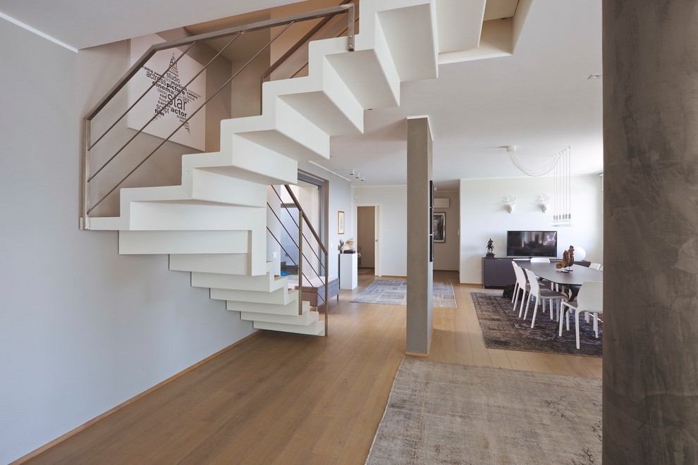 Large modern carpeted l-shaped metal railing staircase in Other with carpeted risers.
