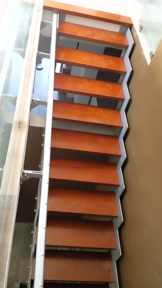 Immagine di una scala a "L" minimal con pedata in legno e nessuna alzata